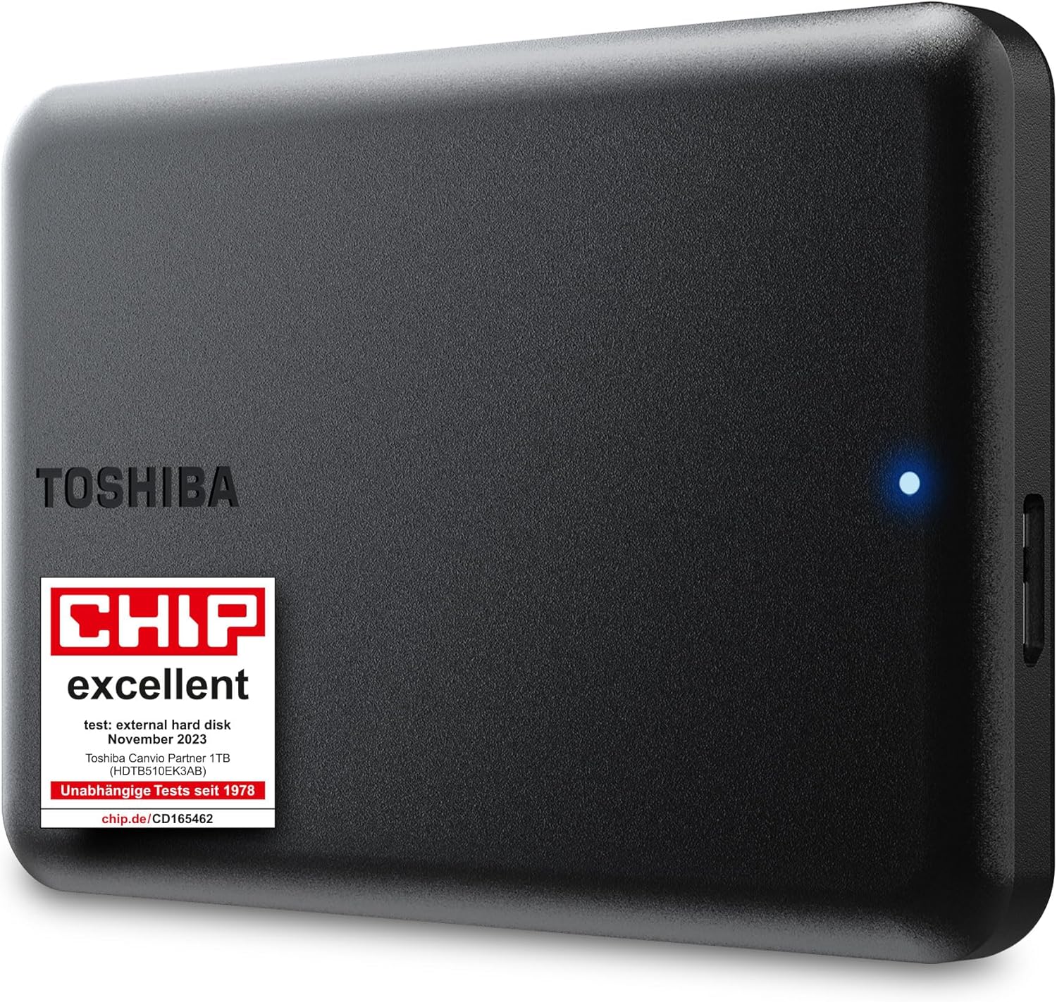 Caja del producto Toshiba Canvio Partner 1TB junto a una consola PS5 y un portátil.